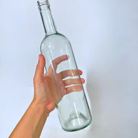 Botella de vidrio transparente tipo Burdeos de 750 ml, ideal para presentación de vino blanco artesanal o industrial.
