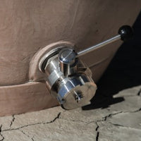 Primer plano de la válvula de salida triclampe de acero inoxidable con palanca de control y conexión Mâcon.