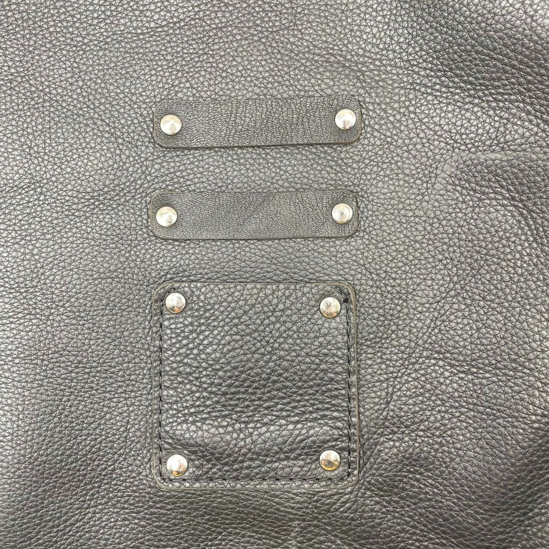 Bolsa frontal del mandil con sacacorchos y libreta listos para el servicio.
