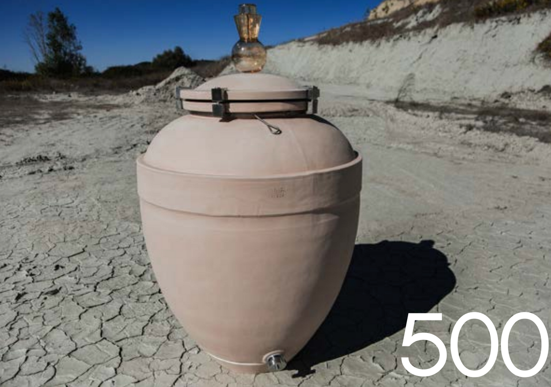 Ánfora Sirio 500 L colocada sobre suelo agrietado, mostrando su válvula inferior de acero inoxidable y tapa de estaño.