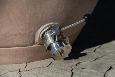 Primer plano de la válvula de salida triclampe de acero inoxidable con palanca de control y conexión Mâcon.