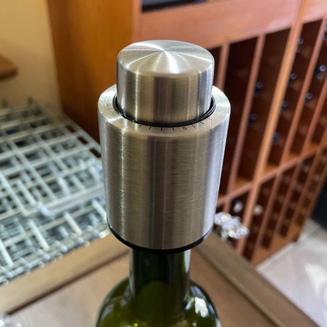 Tapón metálico con bomba integrada colocado sobre botella estándar.